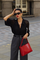 a lady wears a black silk blouse with black loose fit pants